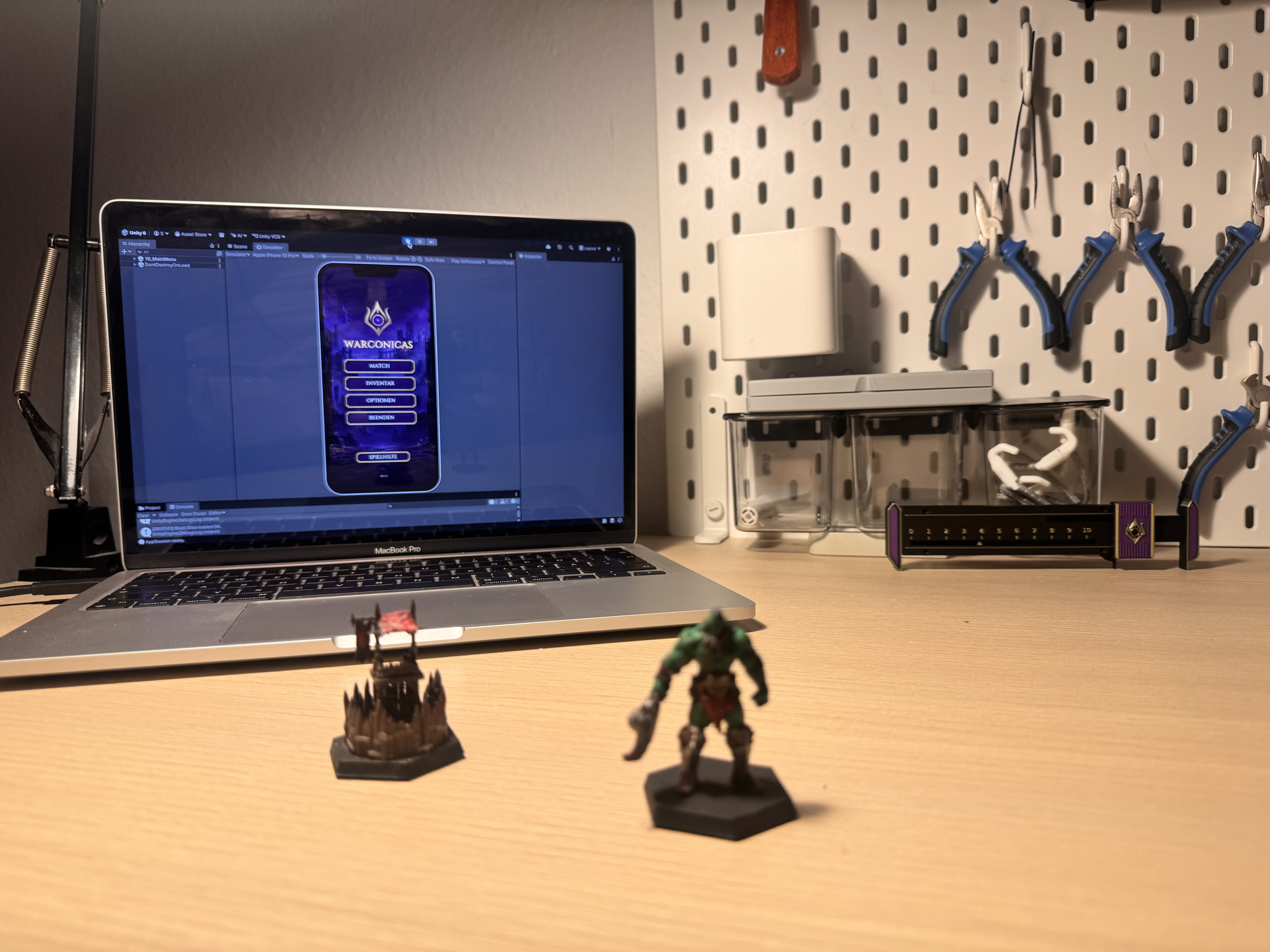 Rogmak and a Rote Hand tower on a workshop desk, with the Warconicas companion app running on a laptop behind them
